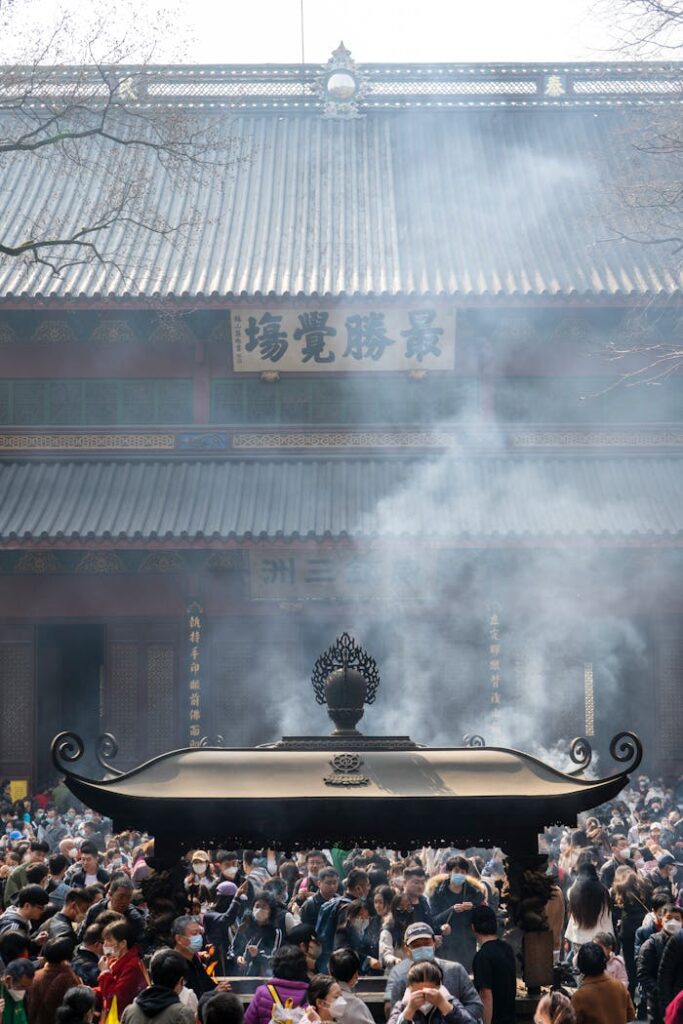 pexels-photo-15816397 A bustling crowd gathers at a Chinese temple for a traditional religious ceremony with incense smoke rising.